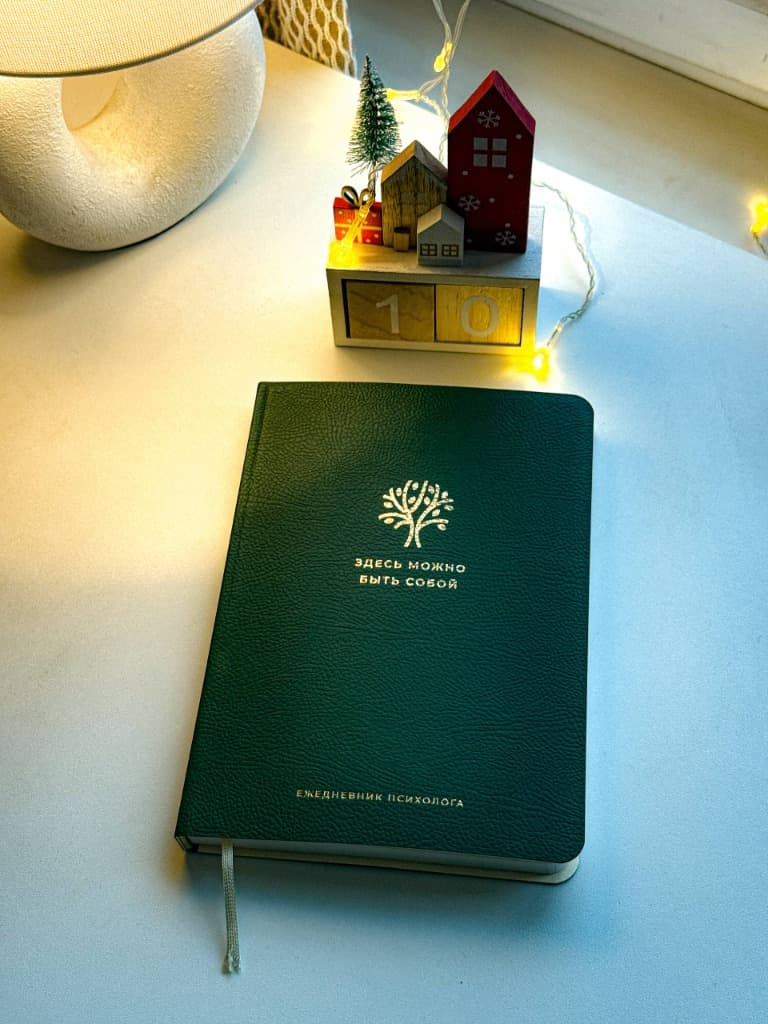 Ежедневник психолога на столе с гирляндой